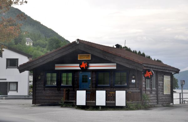 Ferjepassasjerar pissar bak husveggane